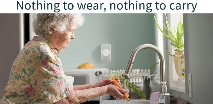 The heading “Nothing to wear, nothing to carry.” above a photo of an elderly woman in a floral blouse washing up at a kitchen sink, the CareAlert plugged into the wall socket beside her.