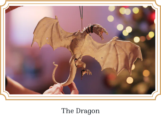The Dragon — the Ukrainian Ironbelly ornament in a gold frame against tree lights.