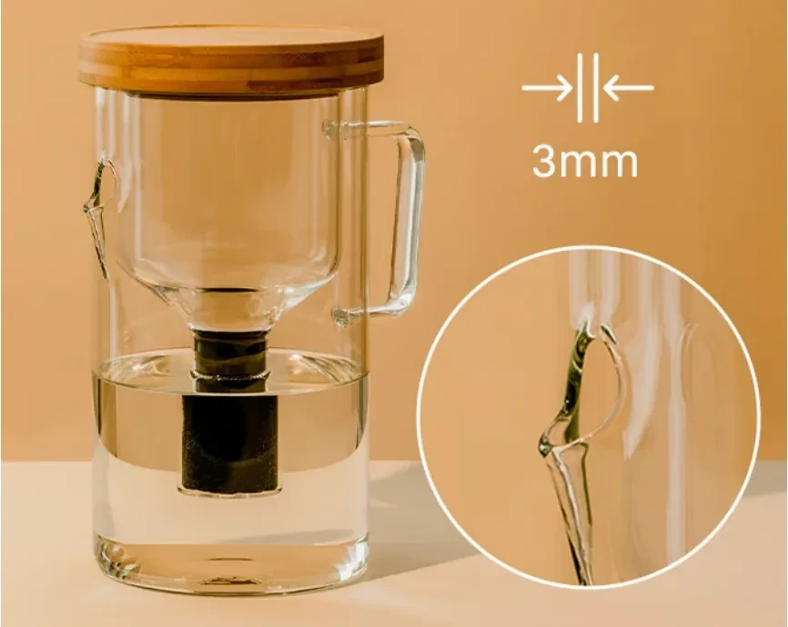 The filled Luvia pitcher, bamboo lid on and filter seated, beside a 3mm wall-thickness callout and a magnified circle of its glass wall.