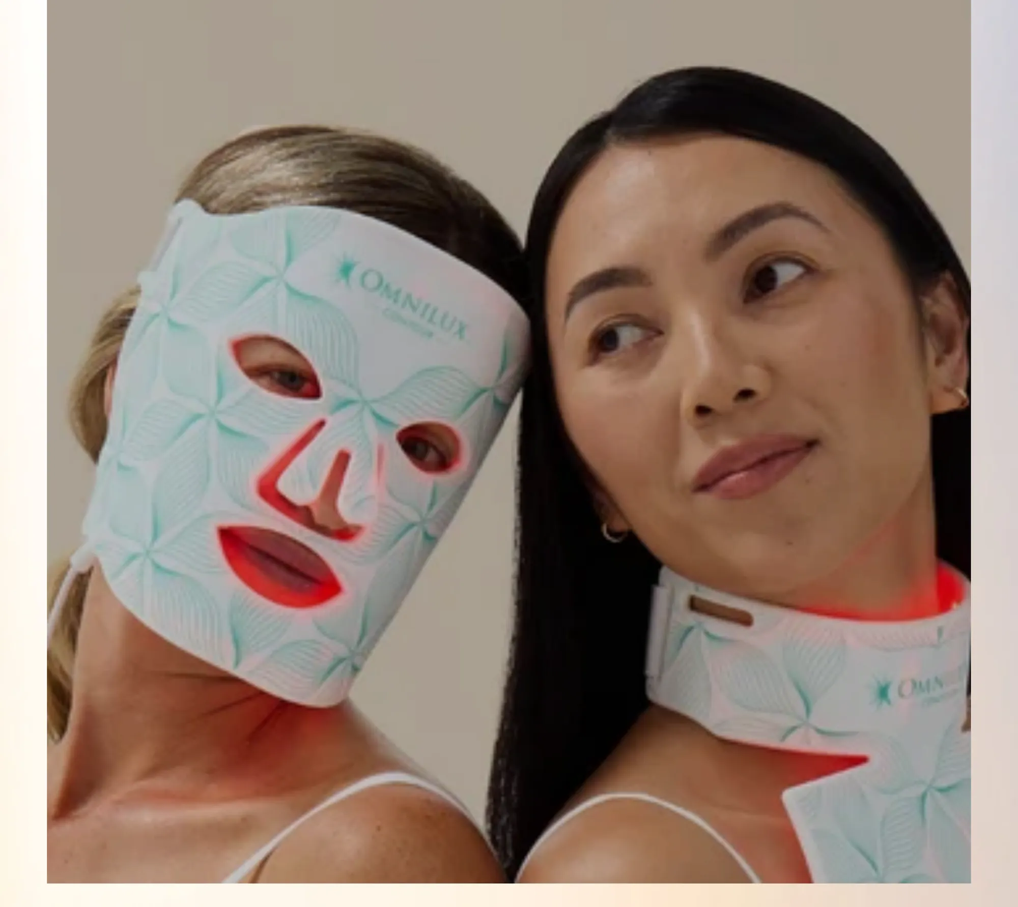 Two women relaxing while wearing Omnilux LED light therapy masks.