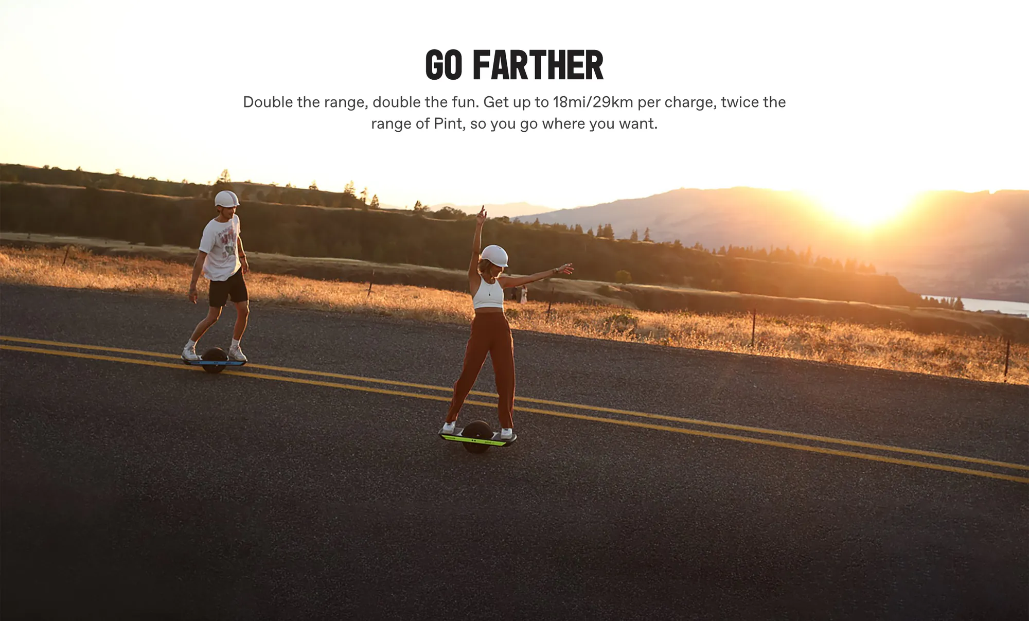 Under 'GO FARTHER' — 'Double the range, double the fun. Get up to 18mi/29km per charge, twice the range of Pint, so you go where you want.' — two riders cruise a sunset backroad.