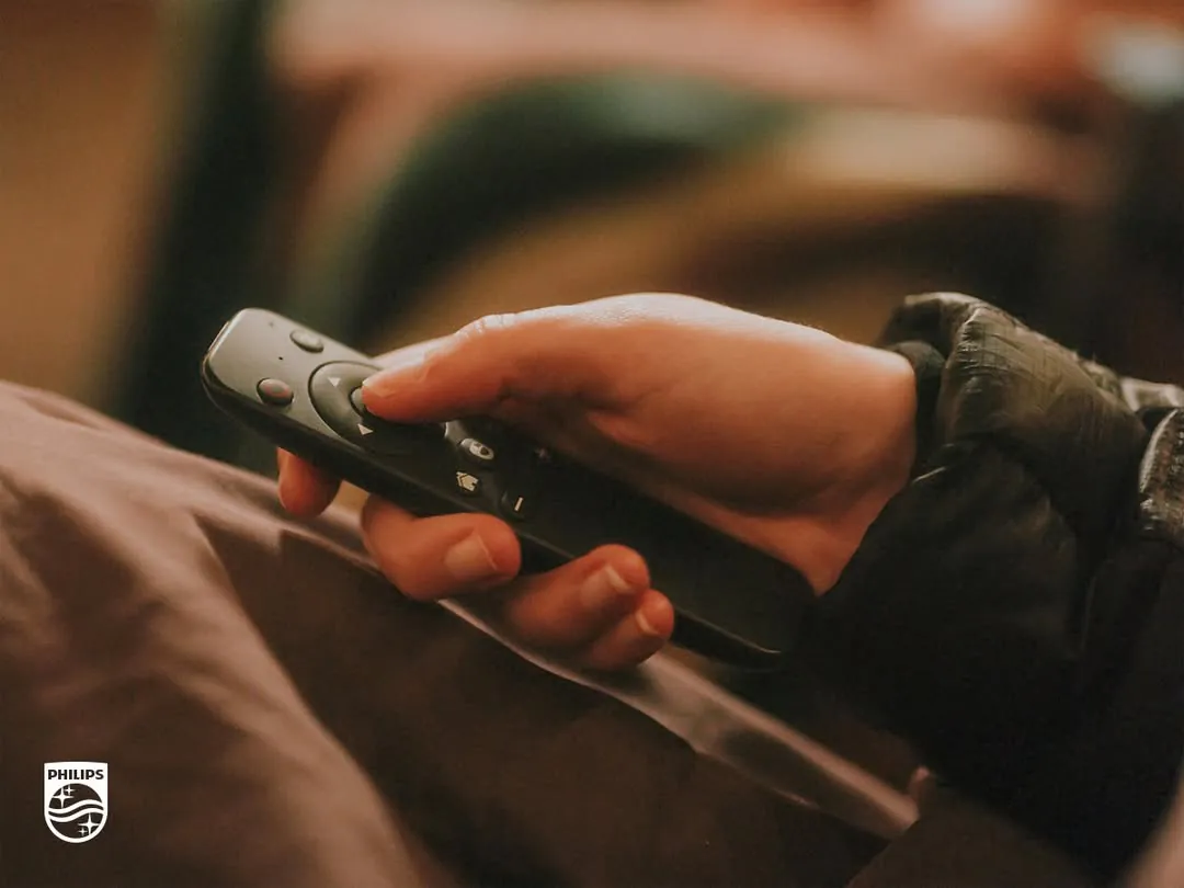 A hand holds the PicoPix Max’s black remote